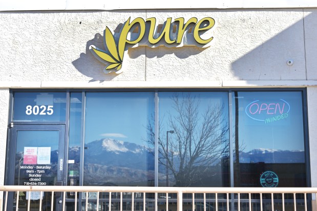 Pikes Peak is reflected in the storefront windows of Pure, a medical cannabis dispensary in Colorado Springs, Colorado, on Wednesday, Jan. 15, 2025. (Photo by Hyoung Chang/The Denver Post)